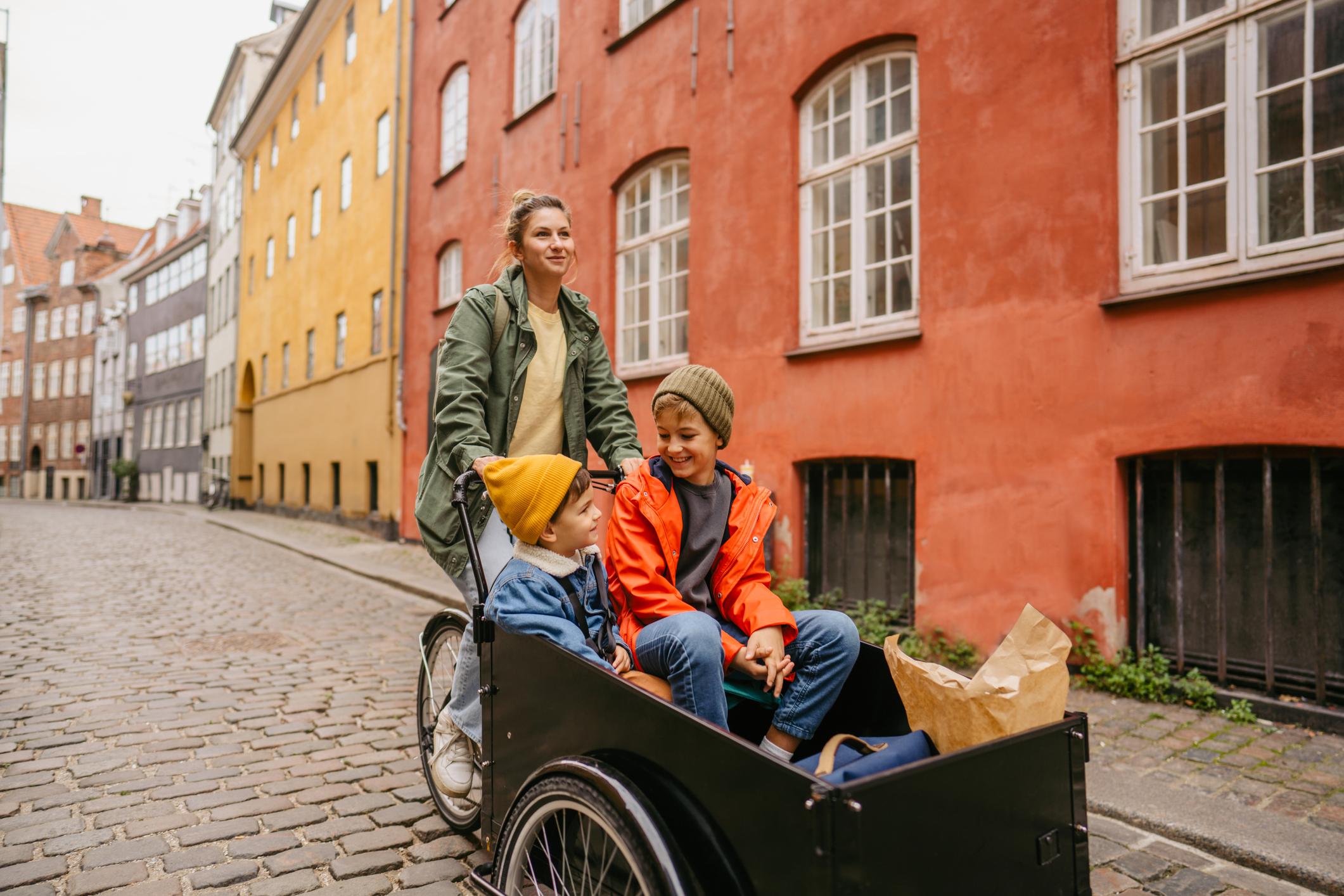 Kvinde cykler med børn